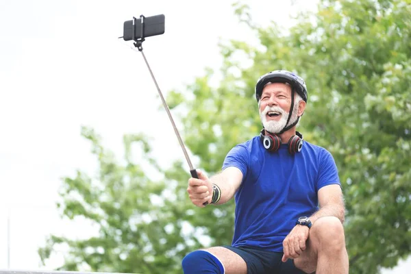 Old sportsman taking selfie using mobile phone camera,healthy lifestyle concept