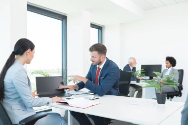 İş adamları ofis toplantısında dizüstü bilgisayarla iş konuşuyorlar.