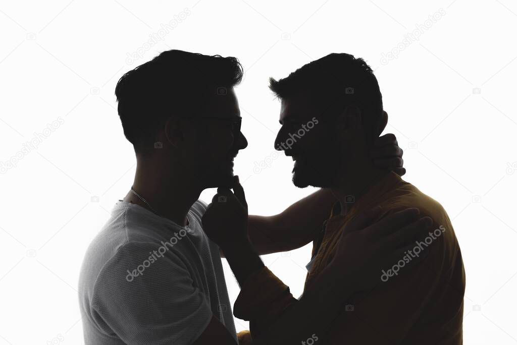 Silhouette of gay couple in love over white background