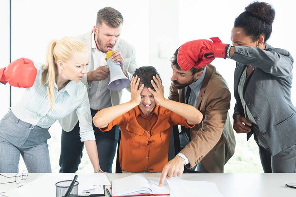 Colleagues screaming at businesswoman in office