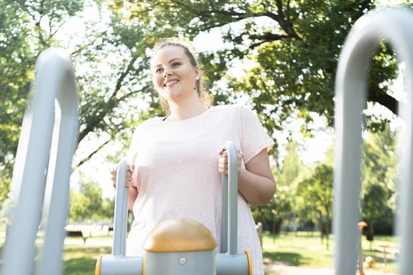 公园里在健身器械上锻炼的胖女人 — 图库照片
