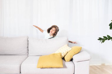 Çocuk evde uçuyormuş gibi yapıyor.