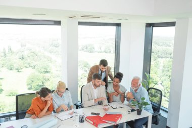 İş ekibi ofis toplantısında işi tartışıyor.