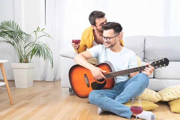 Homosexuell Mann Küssen Seine Freund Während Spielt Gitarre Die Wohnzimmer — Stockfoto