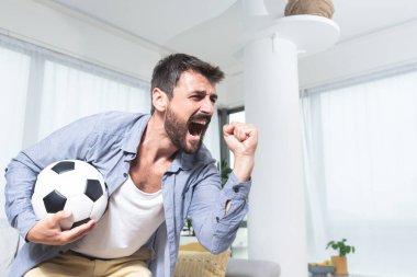 Kazanan yüz ifadesi ve kapalı yumruklu futbol turnuvası izleyen çılgın adam.