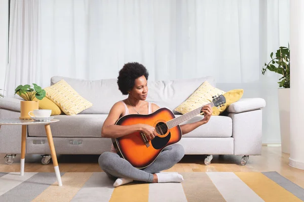 Черная Женщина Играет Гитаре Сидя Полу Гостиной Своего Дома — стоковое фото