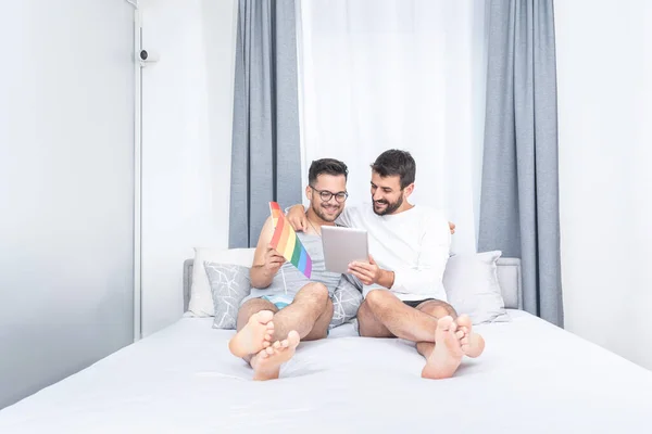 Schwules Paar Mit Regenbogenfahne Und Digitalem Tablet Bett — Stockfoto