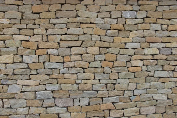 Seamless stone wall made with old bricks. Ancient textured wall close up background.