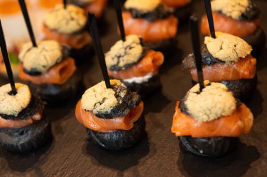 İştah açıcı kanepeler siyah tepsi üzerinde füme somon ile. Ikram Servisi.