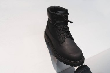Beyaz arka planda siyah ve tek rahat erkekler deri çizme. Closeup yansıması ile.