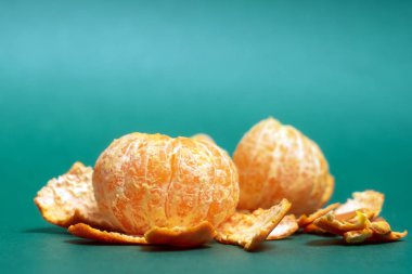 Yeşil zemin üzerine soyulmuş portakal mandalina. Closeup kopya alanı ile.