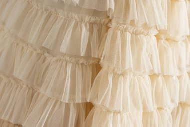 Tül bej lüks elbise ile katlar. Arka plan closeup ayrıntılı.