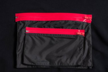 İki pembe su geçirmez fermuarlar ile giysiler üzerinde siyah cepli. Şık mobilya.