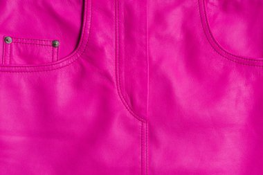 Pembe deri etek dokusu. Perçinüzerinde dikişli malzeme ve beşinci cep. Yakın çekim dokusu.