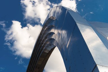 Mavi bulutlu gökyüzüne karşı masif metal yapı. Güzel bir arka plan. Çelik kemer.