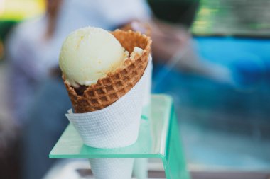 Plastik tutacağa koni içinde sarı dondurma. Lezzetli soğuk tatlı. Boşluğu kopyala.