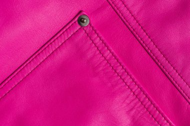 Pembe deri ürün. Perçinli dikişli cep. Yakın çekim dokusu.