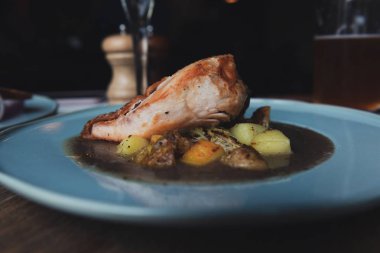 Patates ile bir çorba gevrek bronz deri ile pişmiş tavuk fileto. Ahşap bir masa üzerinde turkuaz plaka. Ev yapımı akşam yemeği. 