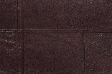 Koyu kahverengi dikişli deri arka plan. Asimetrik dikişler. Boş alanı olan sert bir yüzey. Pahalı bir numune. El işi. Koltuk döşemesi ya da deri ceket..