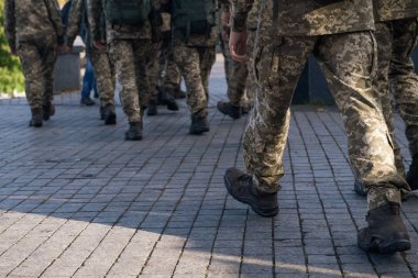Bir grup asker cadde boyunca yürüyorlar. Şehirde askeri üniformalı insanlar var. Yakın çekim..