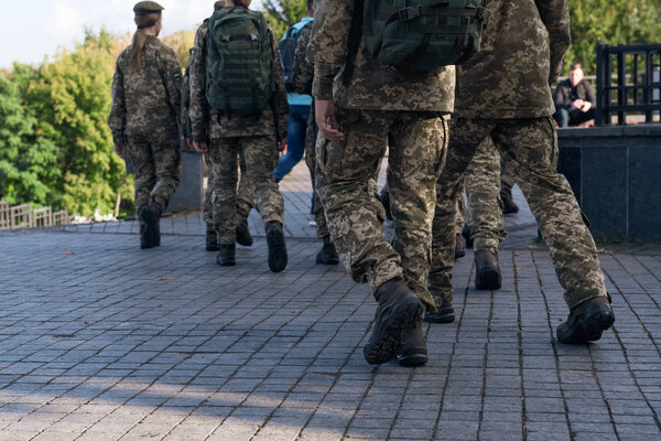 По улицам идет группа солдат. Люди в военной форме в городе. Крупный план
.