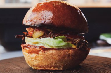 Restorandaki tahtanın üzerinde ördek etli hamburger. Salatalıklı taze çörek ve salatalık turşusu. Yakın çekim..