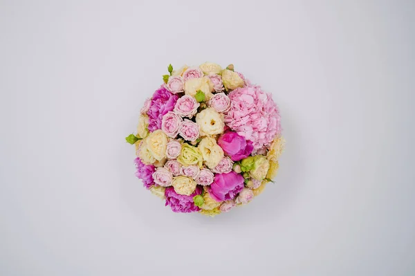 Beautiful colorful flowers bouquet on the white background. Bouquet made of peony and different roses. Wedding flowers. Central composition. View from above.