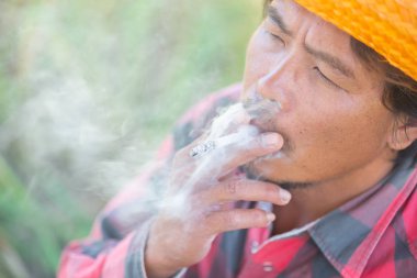Fotoğraf makinesi ile ağzından duman Sigara çiftçi göz.