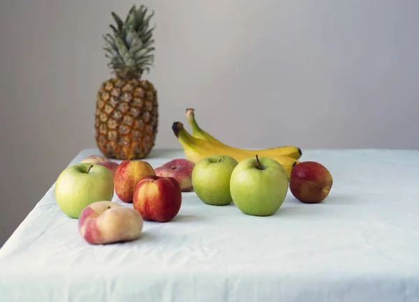Arka plan Food Helathy çiğ vegan yemek. Taze meyve ve smoothies beyaz masa örtüsü üzerinde masada. Yeme, alkali diyet kavramı temiz