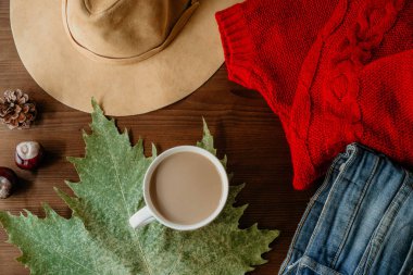 Sonbaharın düz lay ahşap arka plan üzerinde sıcak giysiler fincan kahve ve sonbahar yaprak düşer. Sonbahar sonbahar rahat kavramı