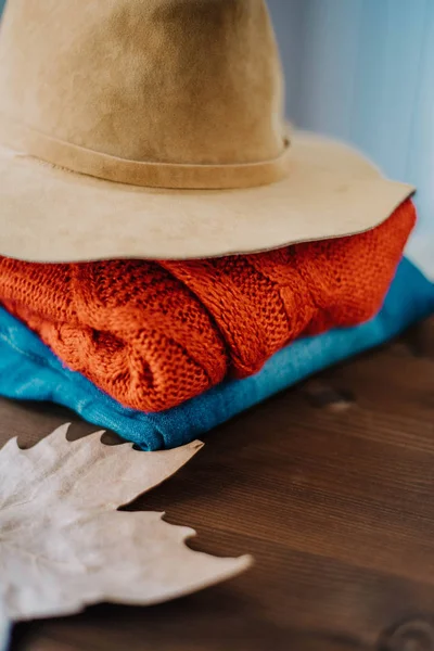 cozy autumn concept, warm autumn clothes and leaf over wooden nackground. Fall concept with warm colors