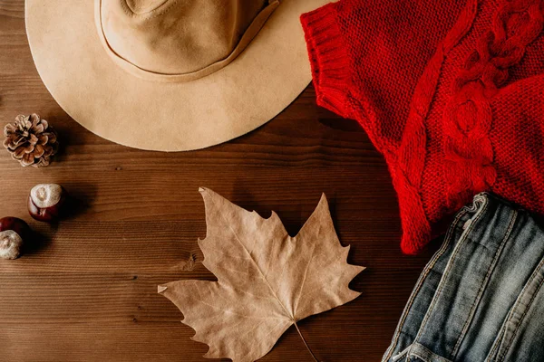 cozy autumn concept, warm autumn clothes and leaf over wooden nackground. Fall concept with warm colors