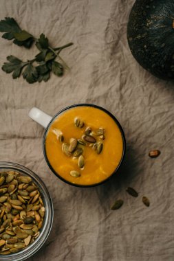 kremalı kabak soupd tohumları üzerinde masa örtüsü, kış sıcak yiyecek Kupası ile düz lay