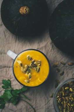 kremalı kabak soupd tohumları üzerinde masa örtüsü, kış sıcak yiyecek Kupası ile düz lay