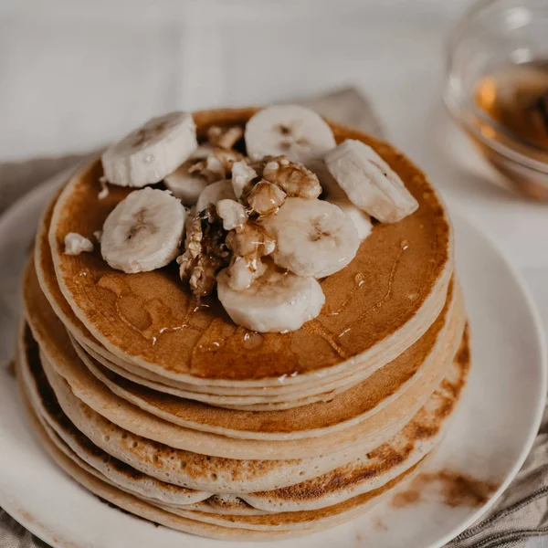 square crop american traditional breakfast with pancakes bananas and nuts close up