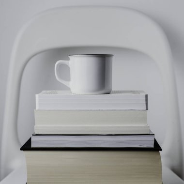 Beyaz kupa kahve veya çay beyaz arka plan üzerinde kitap ile. Minimalist tarzda, eğitim, bilim, araştırma, hygge kavramı 