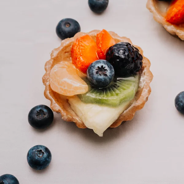 square crop organic healthy french dessert tartlets with fruits over white background