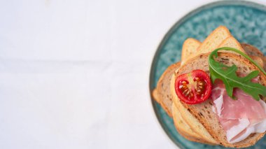 kopya alanı, düz lezzetli taze ekmek parçaları ile ham domates ve roket salata plat üzerinde beyaz arka plan üzerinde göklere 