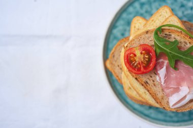 kopya alanı, düz lezzetli taze ekmek parçaları ile ham domates ve roket salata plat üzerinde beyaz arka plan üzerinde göklere 