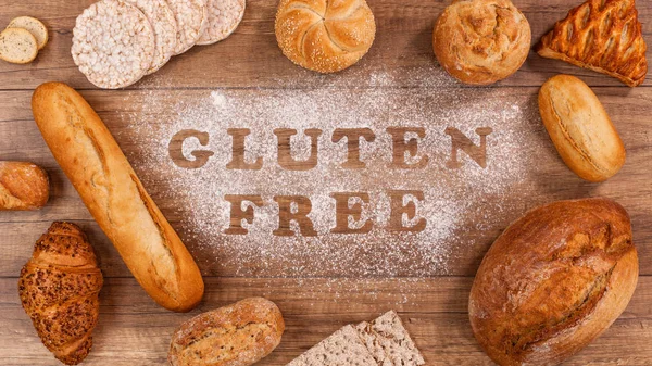 Gluten free bakery products around words written in special flour on the table - the allergen free alternative, top view