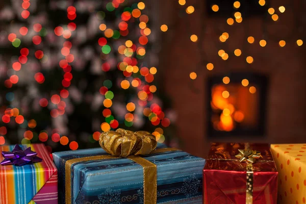 圣诞树和壁炉前的各种五颜六色的圣诞节礼物 — 图库照片