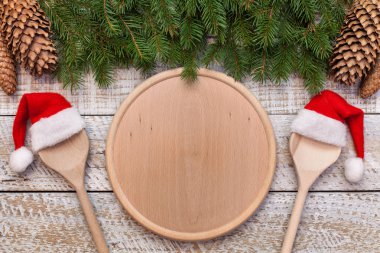 Menü kopya alanı merkezi yuvarlak ahşap plaka ve santa şapka giymiş twoo kaşık ile Noel ve Tatil Sezon