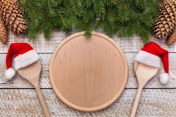 クリスマスとホリデー シーズンの中央の丸い木の板とサンタ帽子をかぶって Twoo スプーンにコピー スペースを持つメニュー — ストック写真