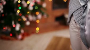 Bir Noel hediyesi kolu - closeup ellerinde, bulanık xmas ağacı arka planda dışarı uzanan veren genç kız