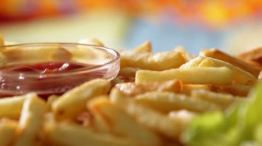 Makro closeup yeme patates kızartması - el alarak ve ketçap bir kızarmış patates sopa daldırma