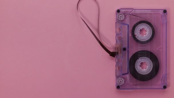 Retro Music Compact Cassette Tape Hanging Withrawing Playing Pink Background — Stock Video