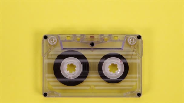 Retro Music Compact Cassette Reeling Tape Yellow Background Closeup — Stock Video