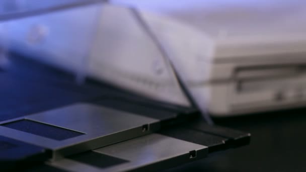 クローズ アップの古いボロボロのラップトップ コンピューターにフロッピー ディスクを挿入する手 — ストック動画