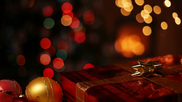 Χριστουγεννιάτικα Στολίδια Και Τυλιγμένο Δώρο Μπροστά Από Τζάκι Και Θολή — Αρχείο Βίντεο