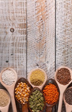 Çeşitli tohum ve hububat tahta kaşıklar üzerinde hırpalanmış ahşap sur içinde